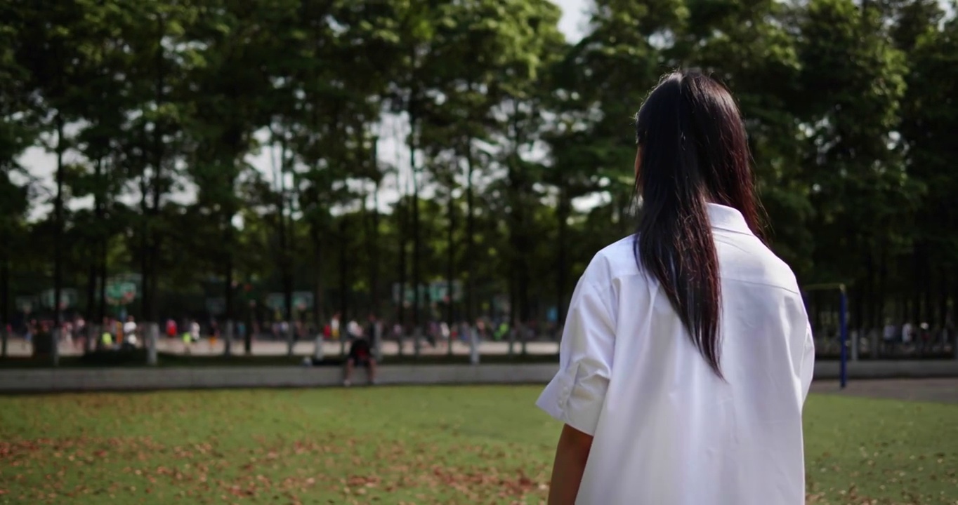 亚洲美女在公园里通过耳机听音乐。视频素材