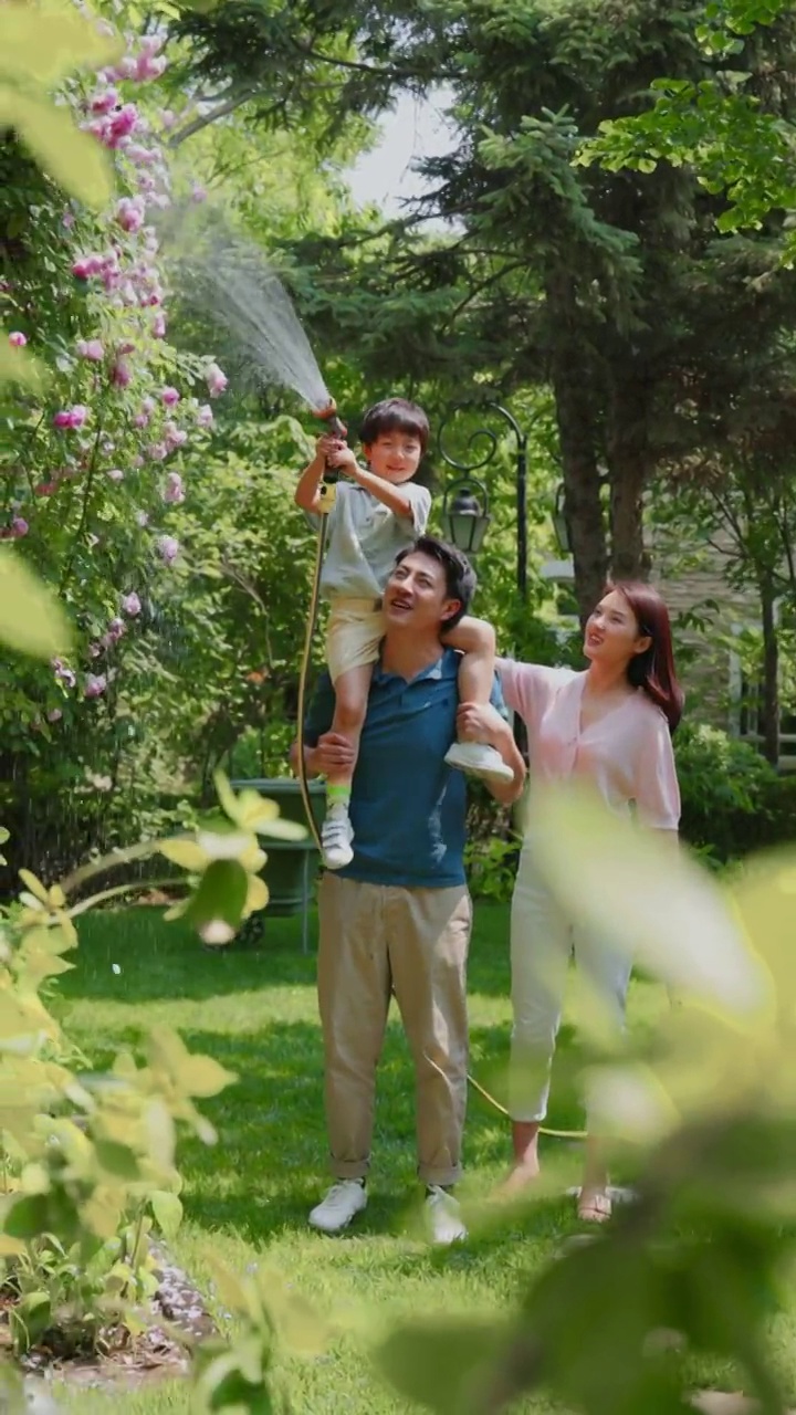 幸福的一家三口在院子里浇水视频下载
