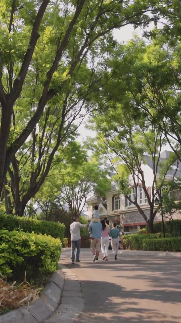 幸福六口之家在小区内散步的背影视频素材