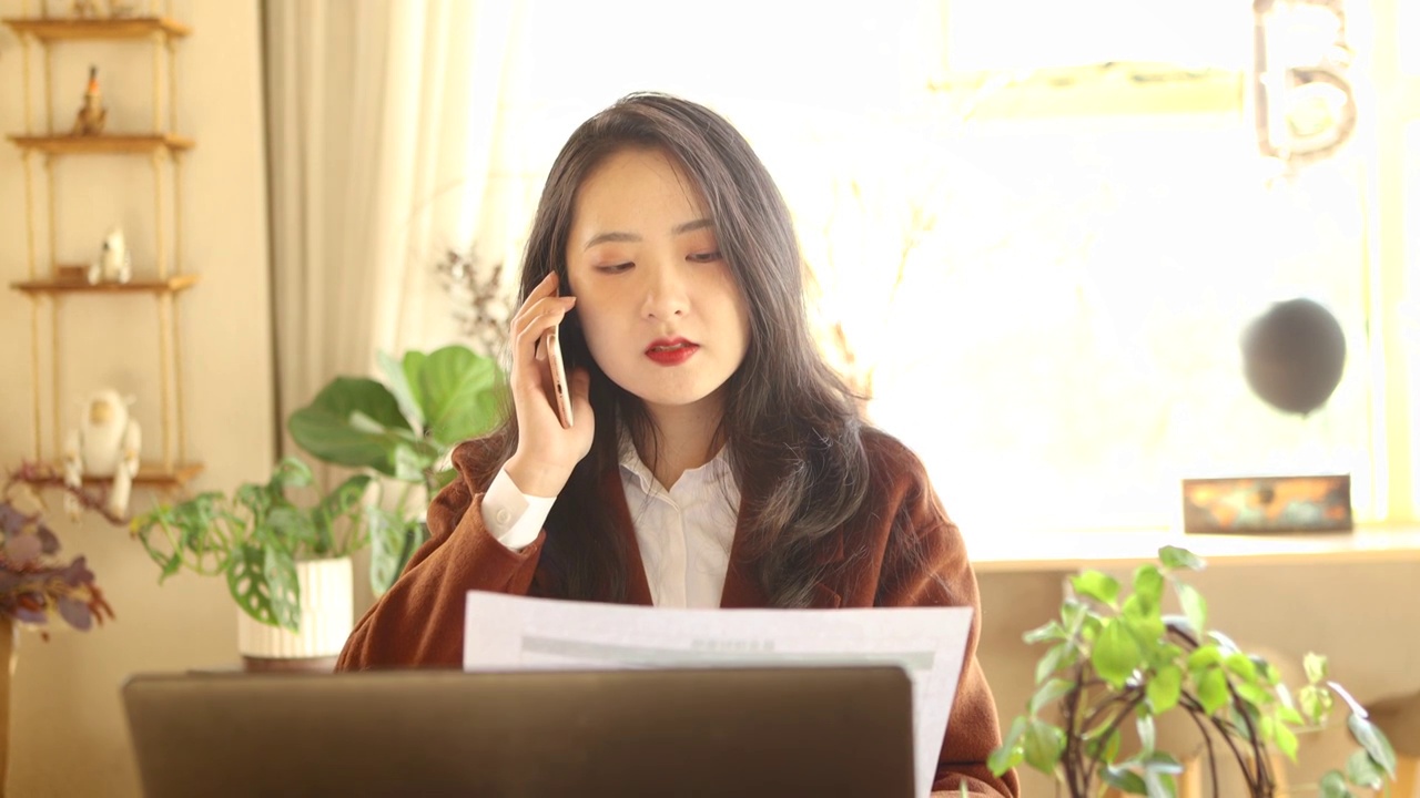 一个亚洲美女商人在室内办公打电话视频素材