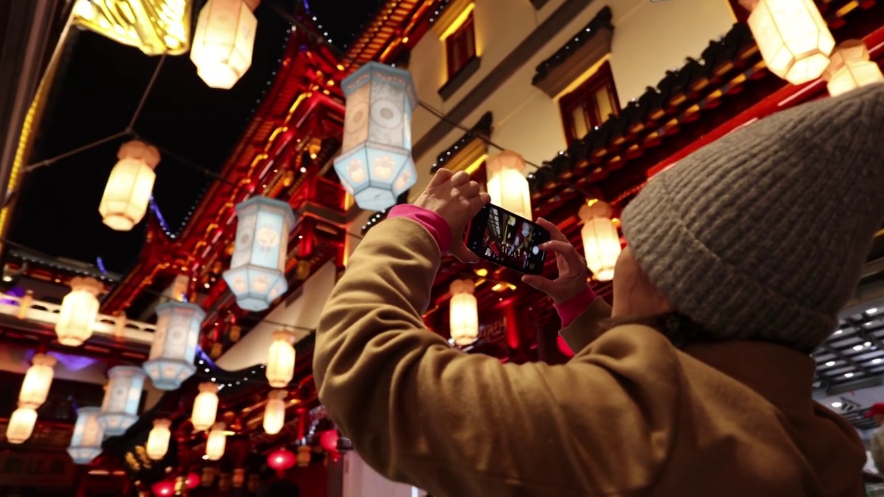 夜晚在上海豫园用手机拍照的女人背影视频素材