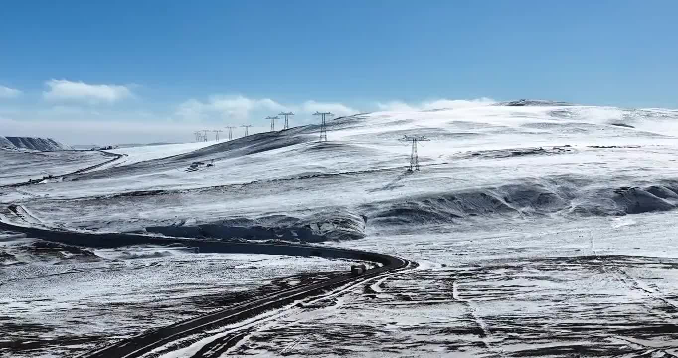航拍翻越青藏高原唐古拉山口的输电塔和G109国道道路视频素材