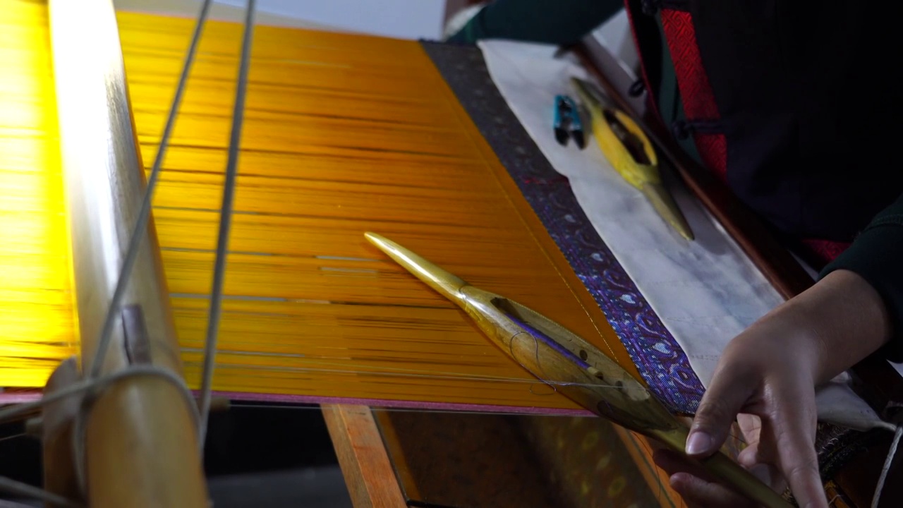 妇女工人正在使用和演示如何在中式古老的木质织布上编制布料绒线特写视频下载