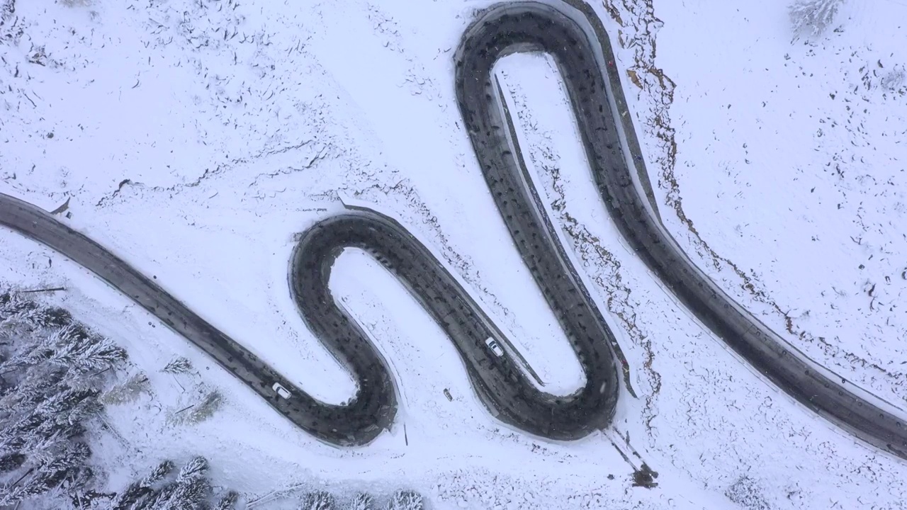 汽车驶过林海雪原中的蜿蜒公路视频素材