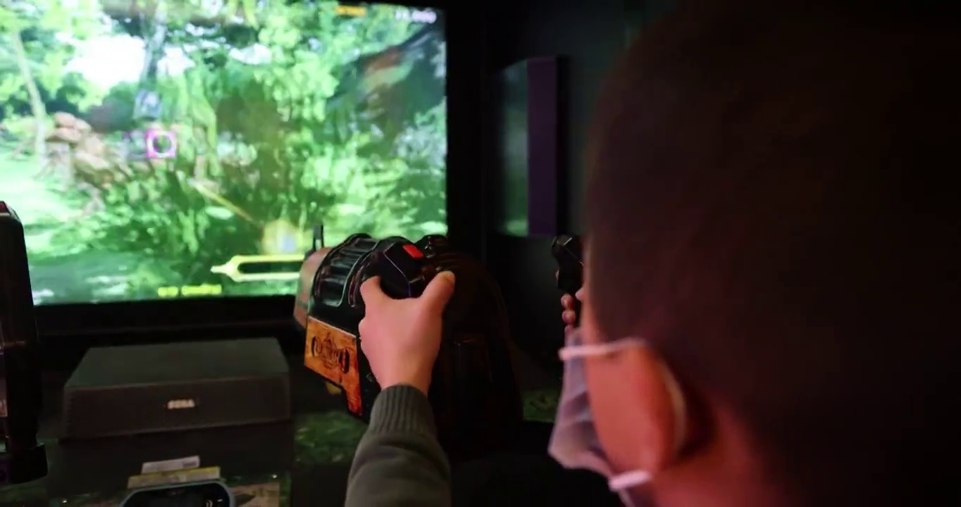 游戏玩乐：小男孩正在游戏厅玩射击类电子游戏视频素材