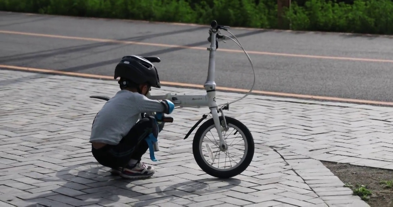 自行车载具：小男孩学习维修自行车掉下来的传动链条视频下载