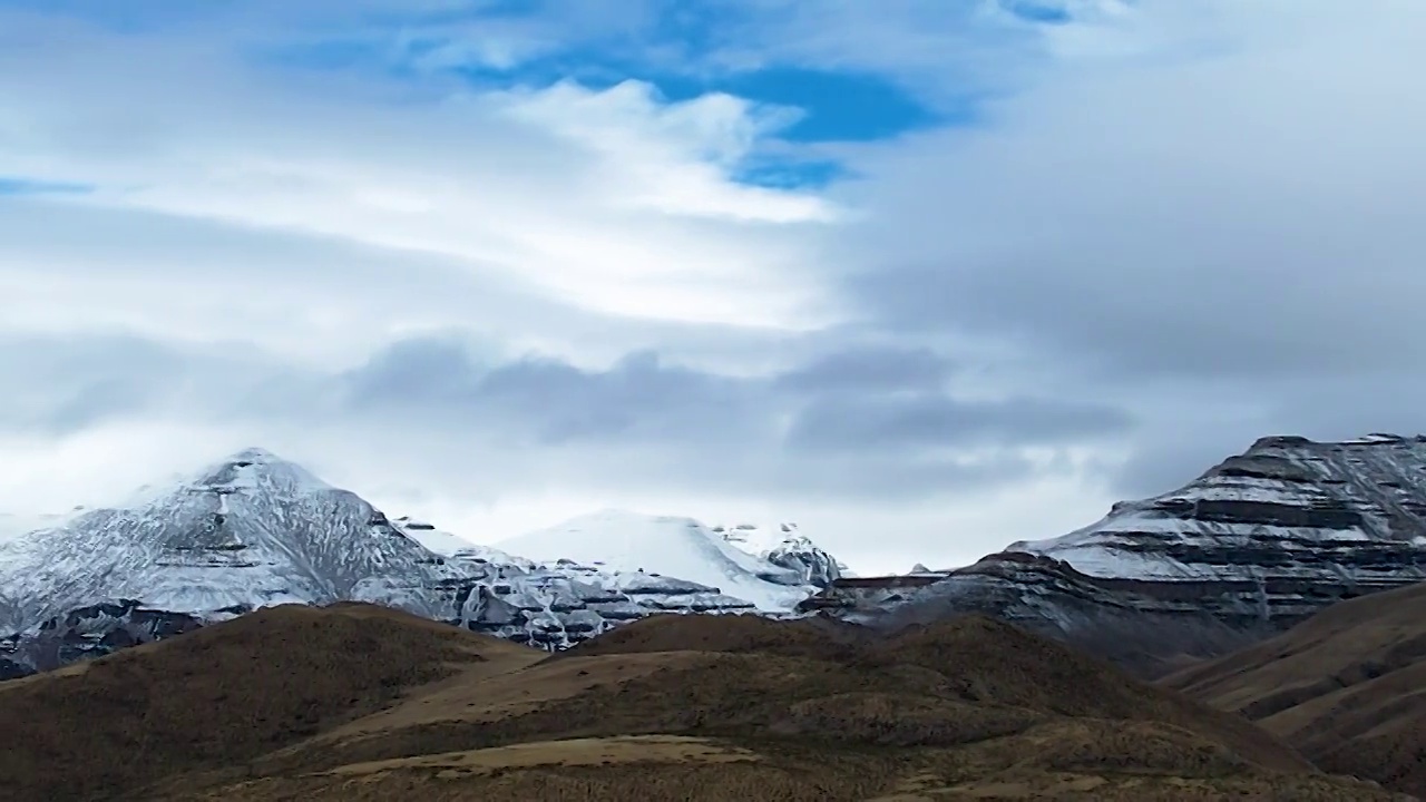 西藏阿里神山冈仁波齐航拍，高原雪山在蓝天白云下圣洁美丽，神山脚下的塔钦镇是转山的起始点视频素材
