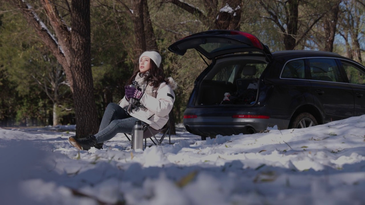 青年女人坐在雪地里喝热水视频下载