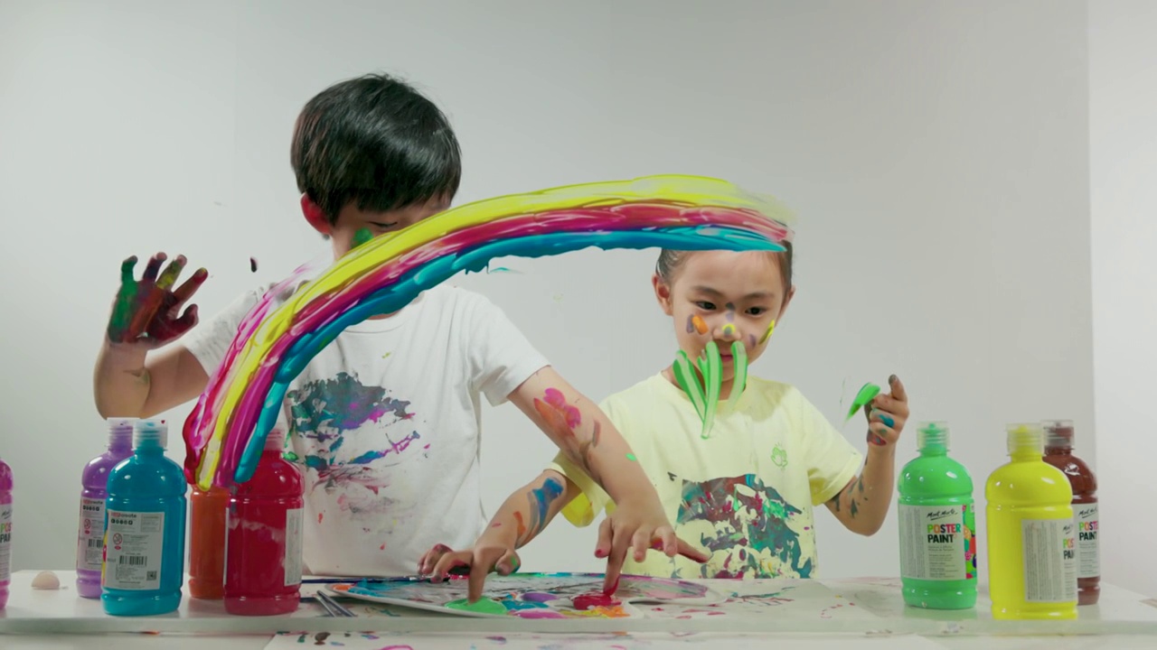 小男孩和小女孩用涂满颜料的手画画视频下载