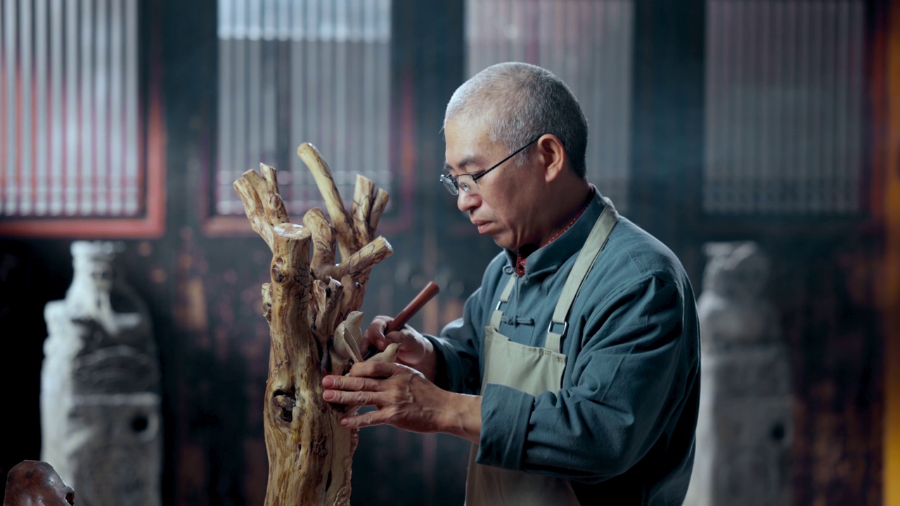 在树根上认真雕刻的工匠师视频素材