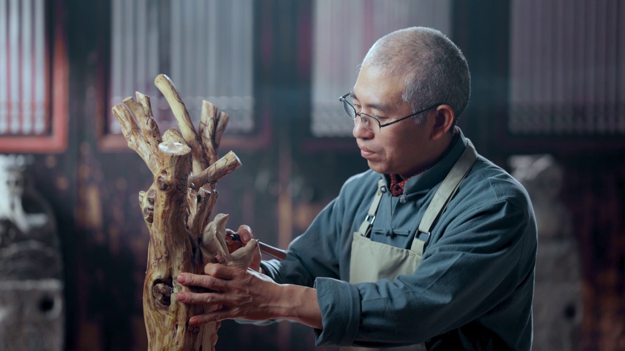 在树根上认真雕刻的工匠师视频素材