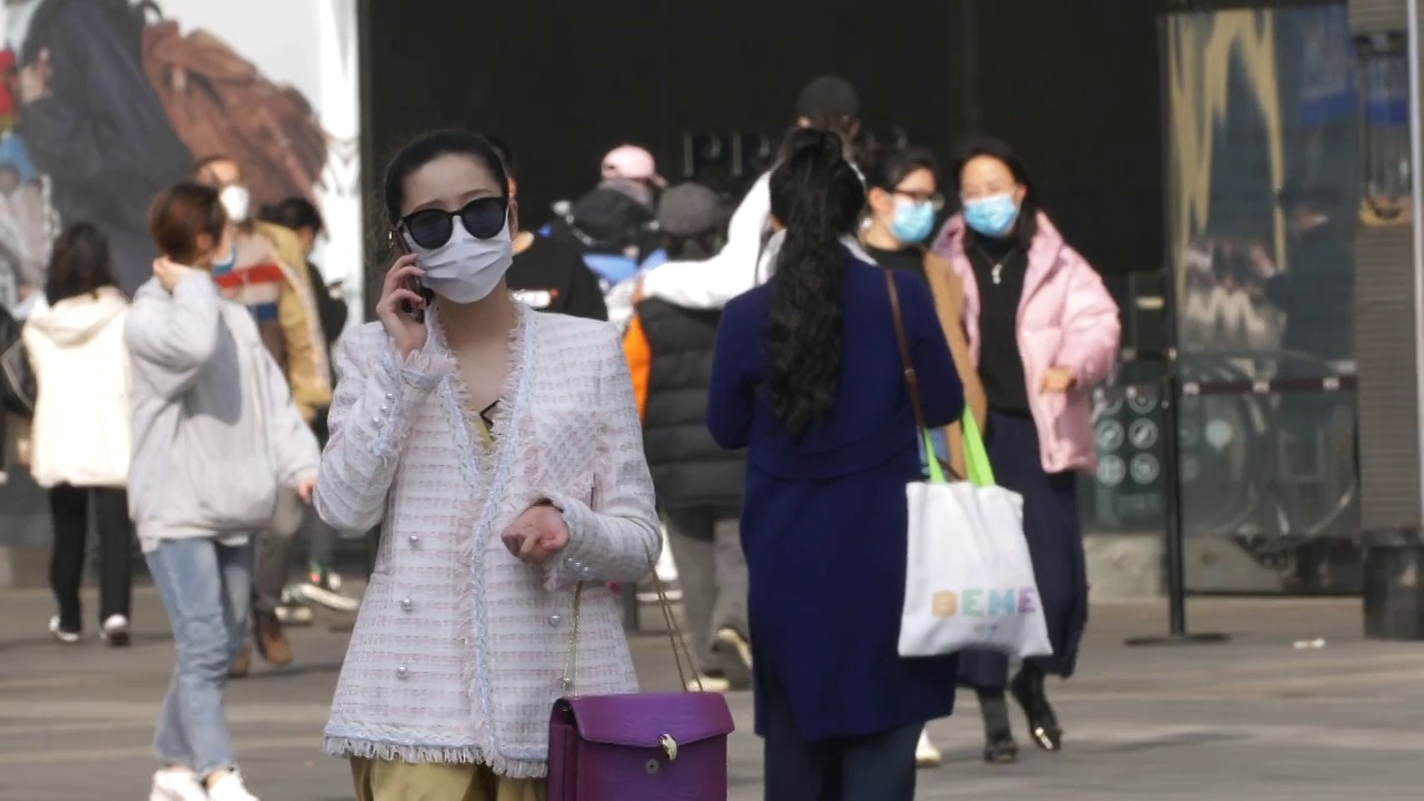 戴墨镜的女人戴着口罩在街头打电话慢镜头视频素材