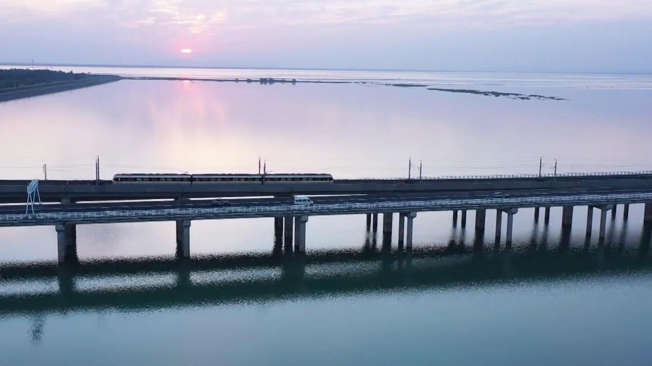 日落时分的南京石臼湖上的行驶的地铁轨道交通视频素材