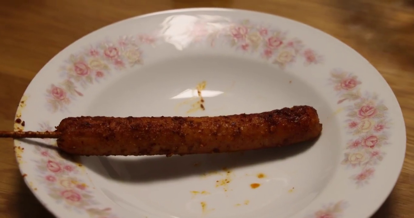 烧烤美食：一串麻辣味的火腿肠烤串视频素材