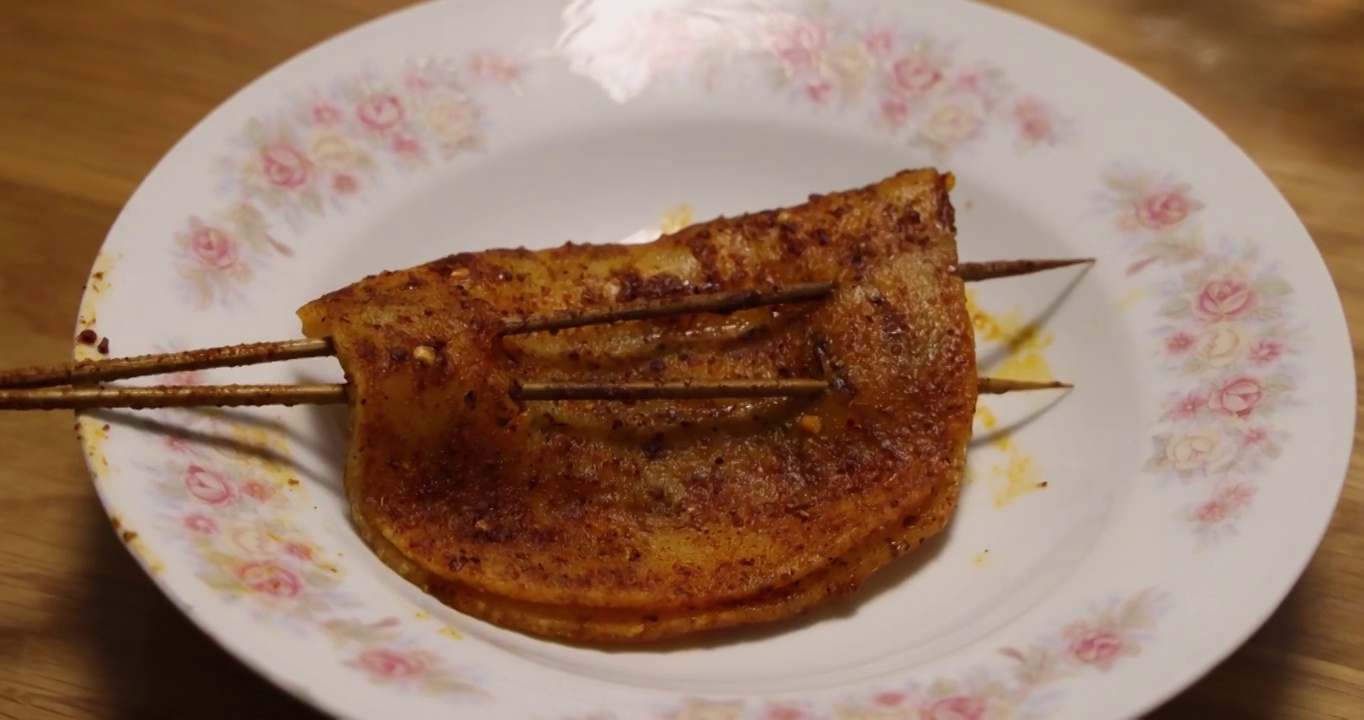 烧烤美食：一串麻辣香脆的烤年糕视频素材