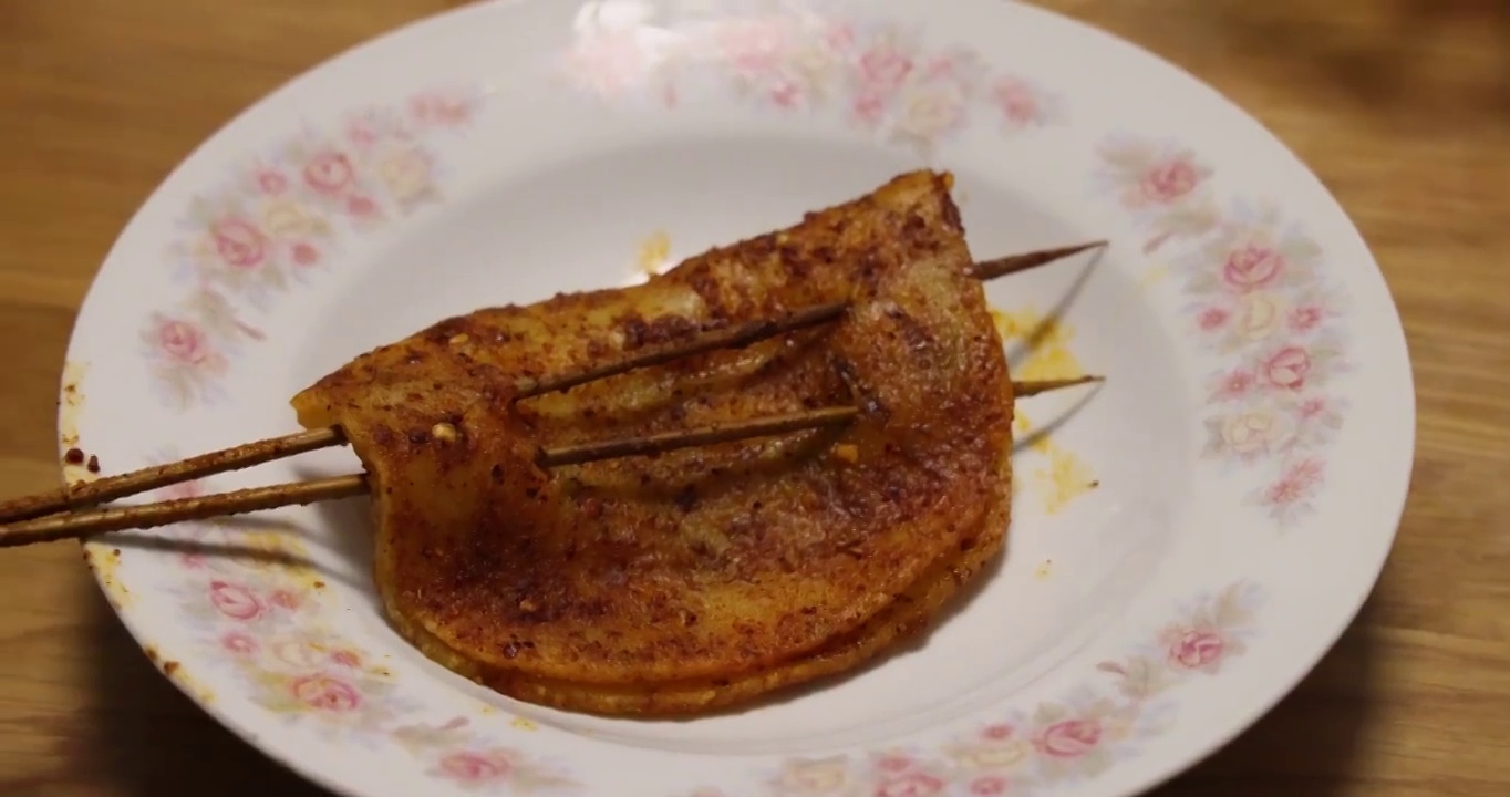 烧烤美食：一串麻辣香脆的烤年糕视频素材
