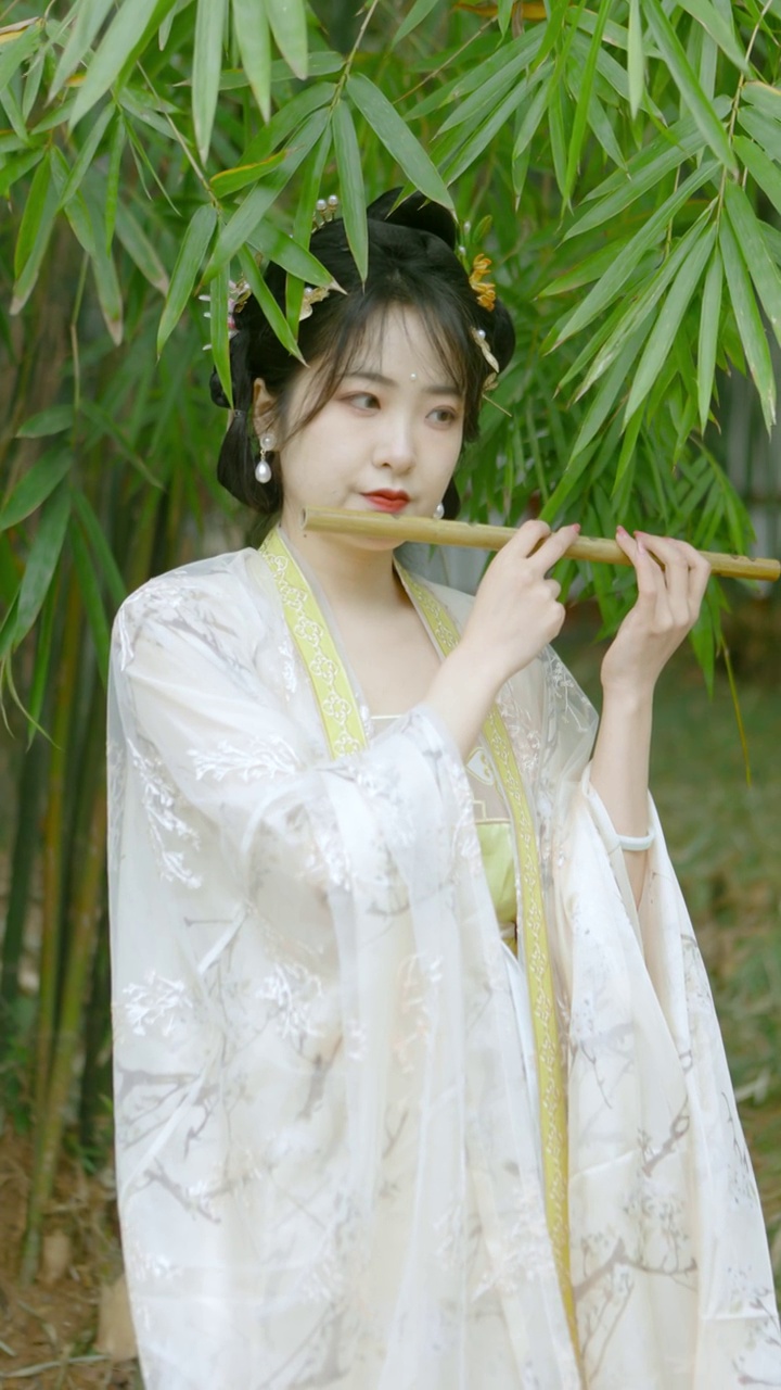 中国美女穿着汉服在竹林里吹奏长笛视频下载