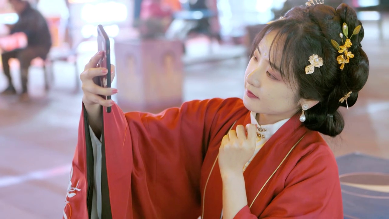 夜晚的城市里中国美女穿着汉服使用手机自拍视频下载