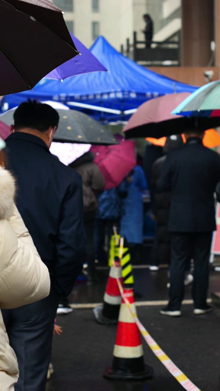 下雨天亚洲中国人城市居民排队做核酸做检查视频素材