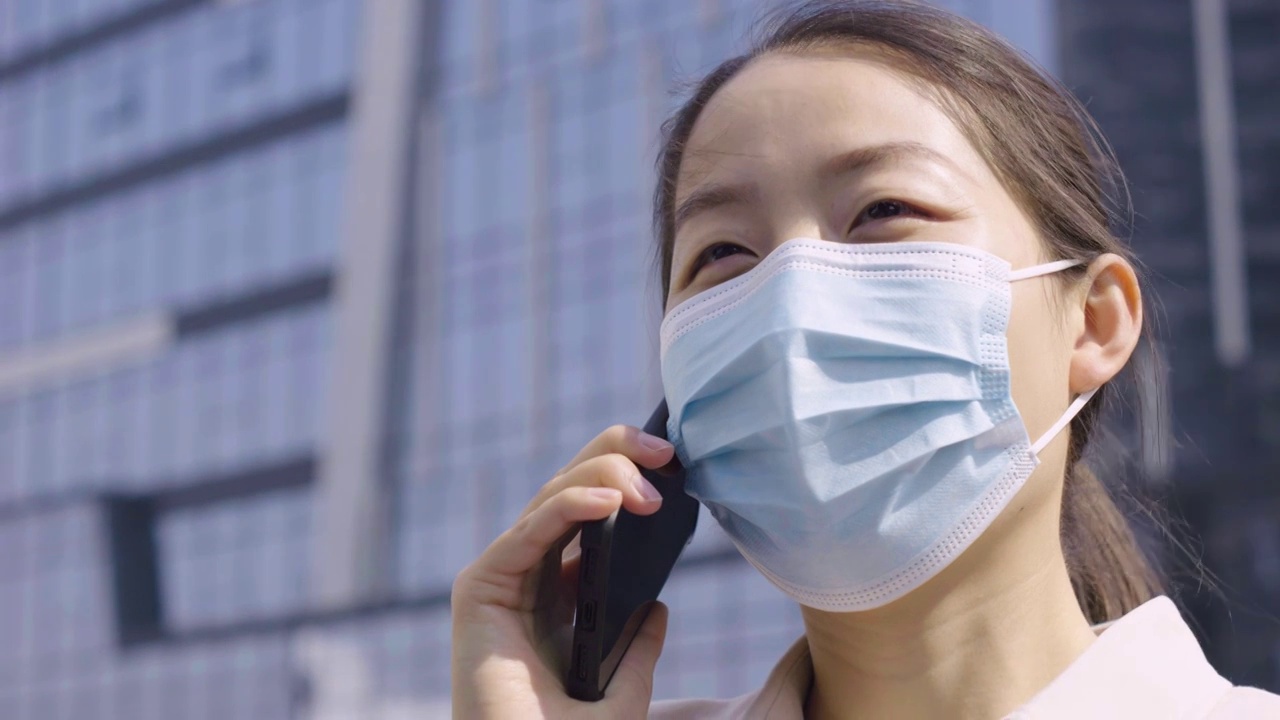 亚洲人中国女性戴口罩户外办公打电话玩手机视频下载
