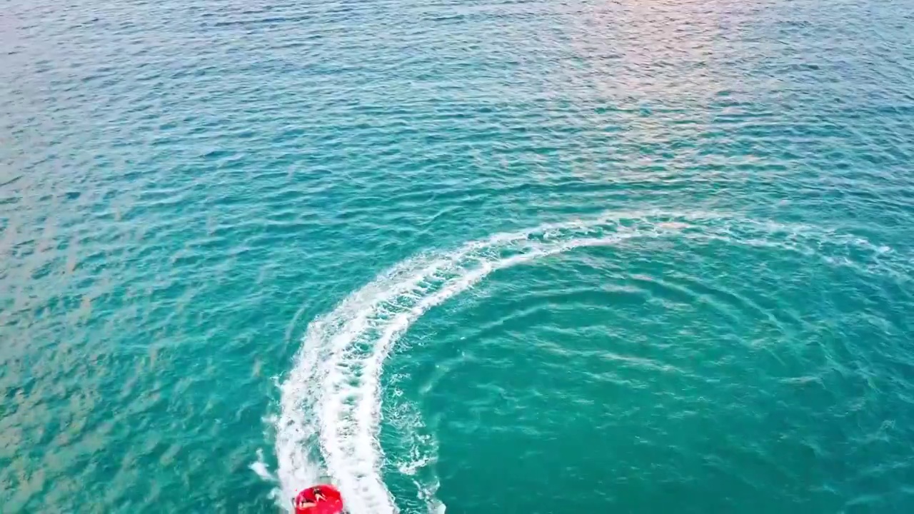 海南省三亚市亚龙湾水上运动项目快艇拖曳伞航拍视频素材