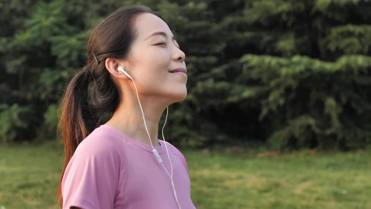 亚洲中国女性女士带耳机运动前后热心运动视频素材