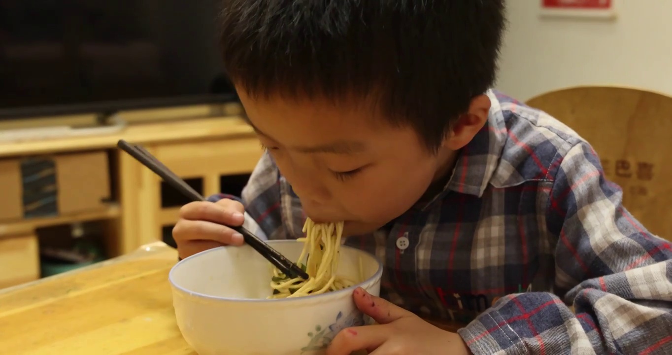 人像美食：小男孩津津有味的吃着凉面视频素材
