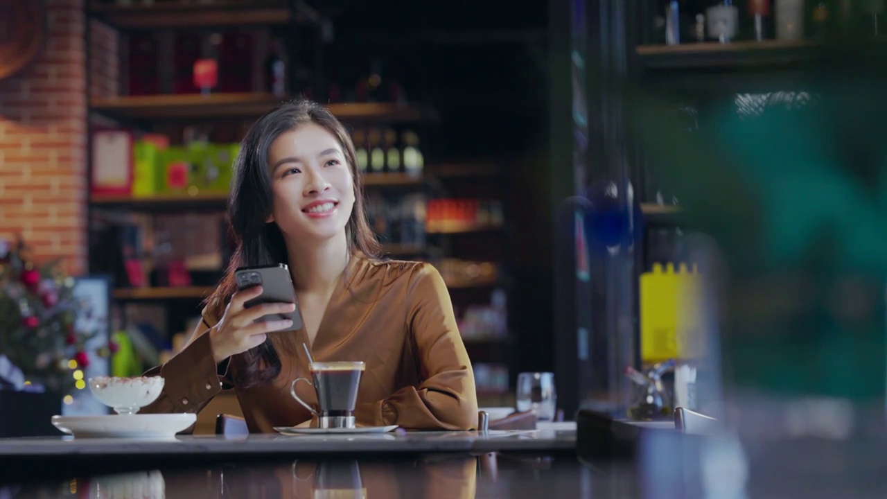 咖啡厅内边喝咖啡边使用手机的青年女人视频下载