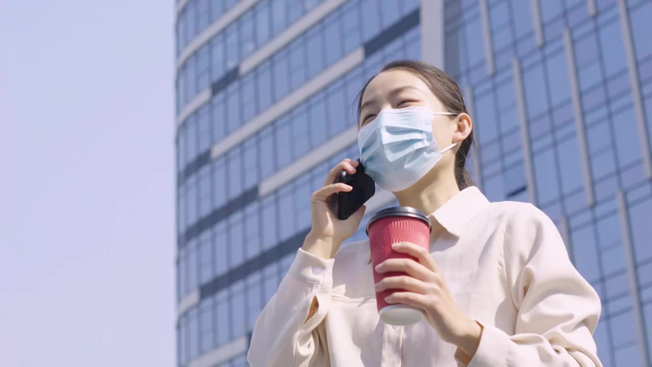 亚洲人中国女性戴口罩户外办公打电话玩手机视频素材