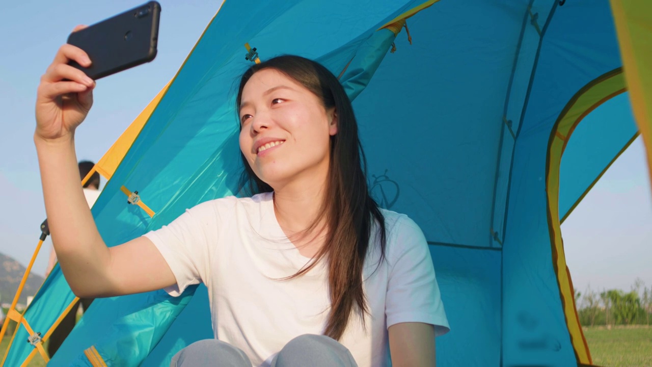 亚洲人中国人女士美女户外露营帐篷内玩手机视频素材