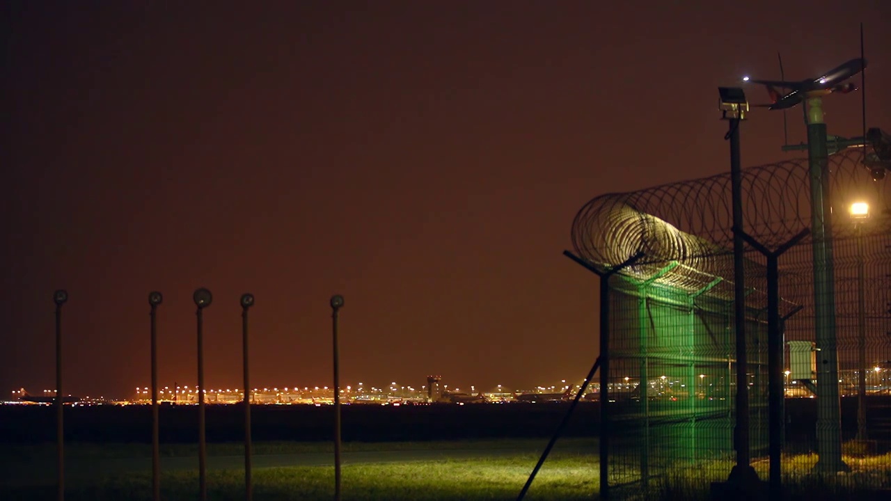 飞机在夜间起飞越过机场围栏视频素材