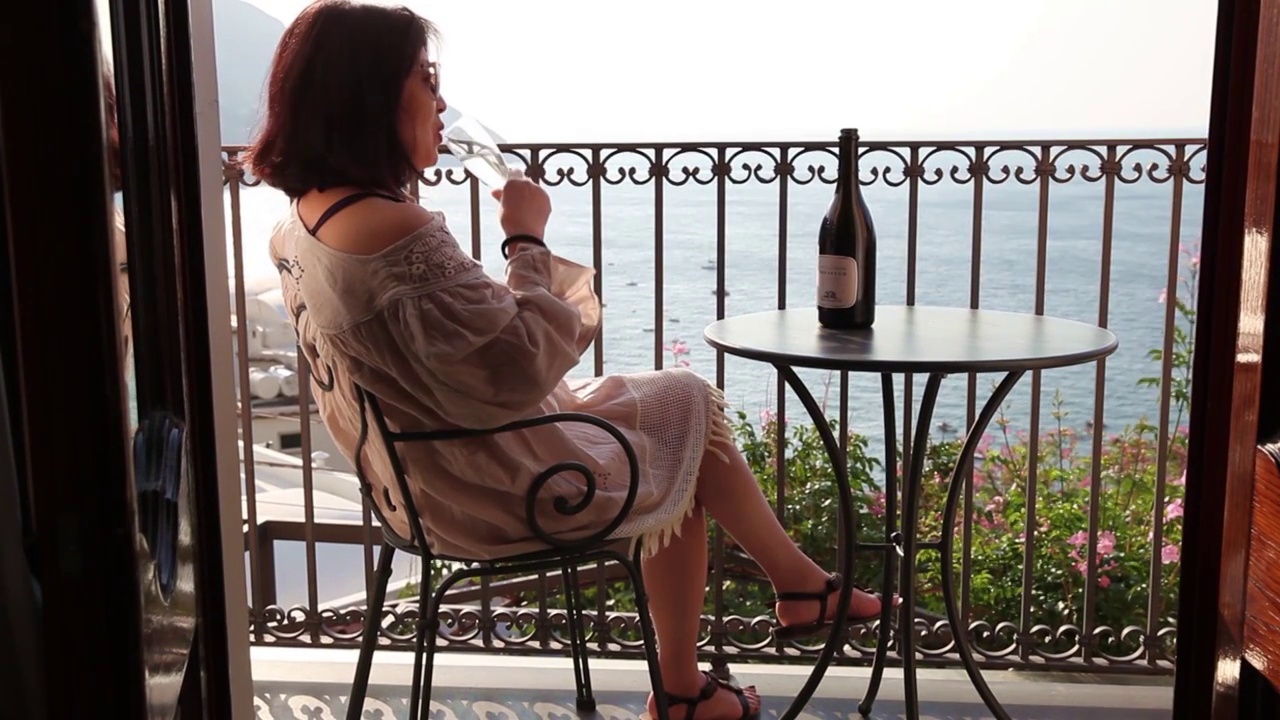 在海边度假酒店阳台喝香槟的女人视频素材