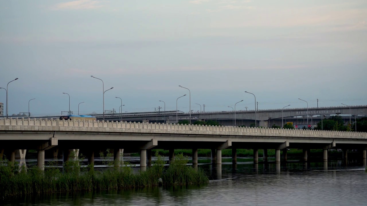 夕阳中行驶在晓月湖高架桥上的高速列车视频素材
