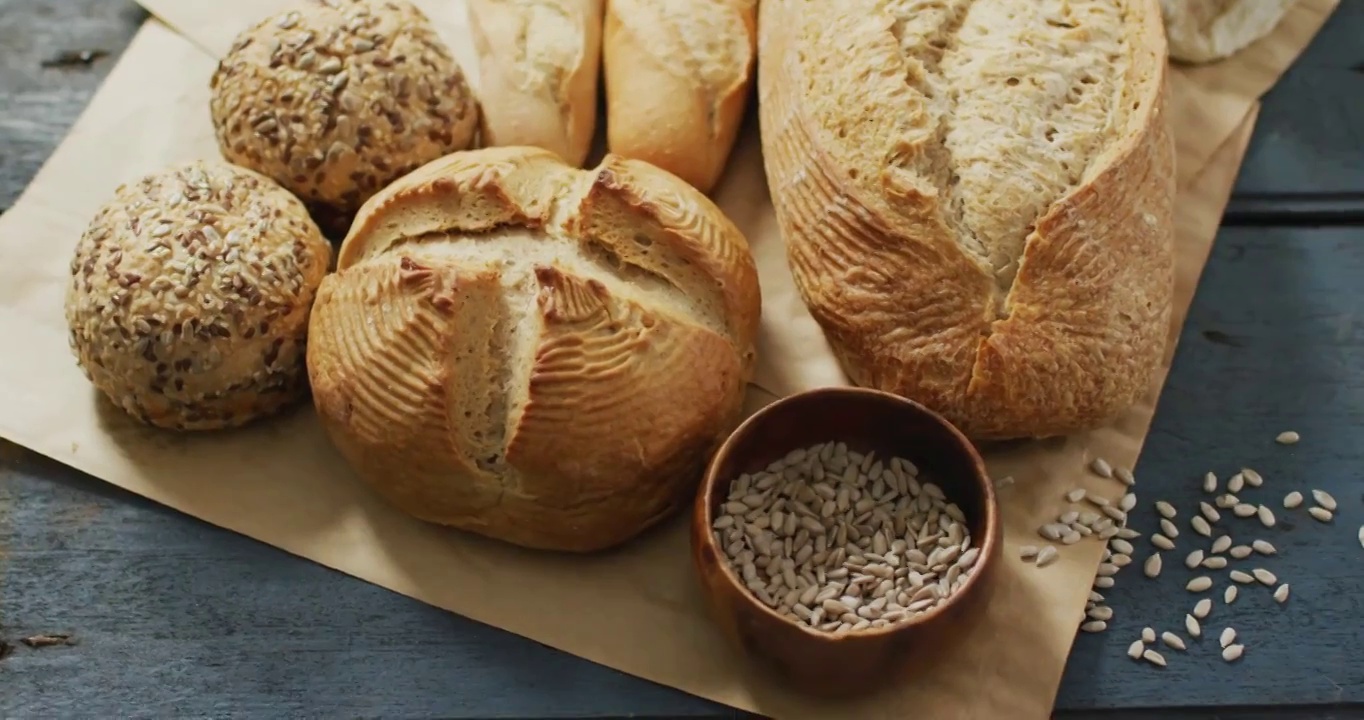 木制工作台上烤纸上的面包卷和面包的视频视频下载