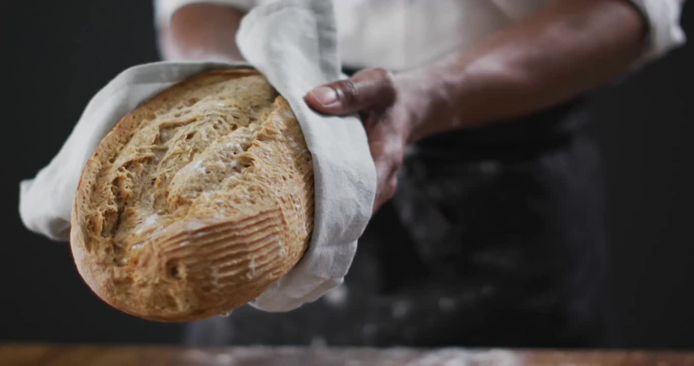 视频厨师拿着黑色背景的面包视频下载