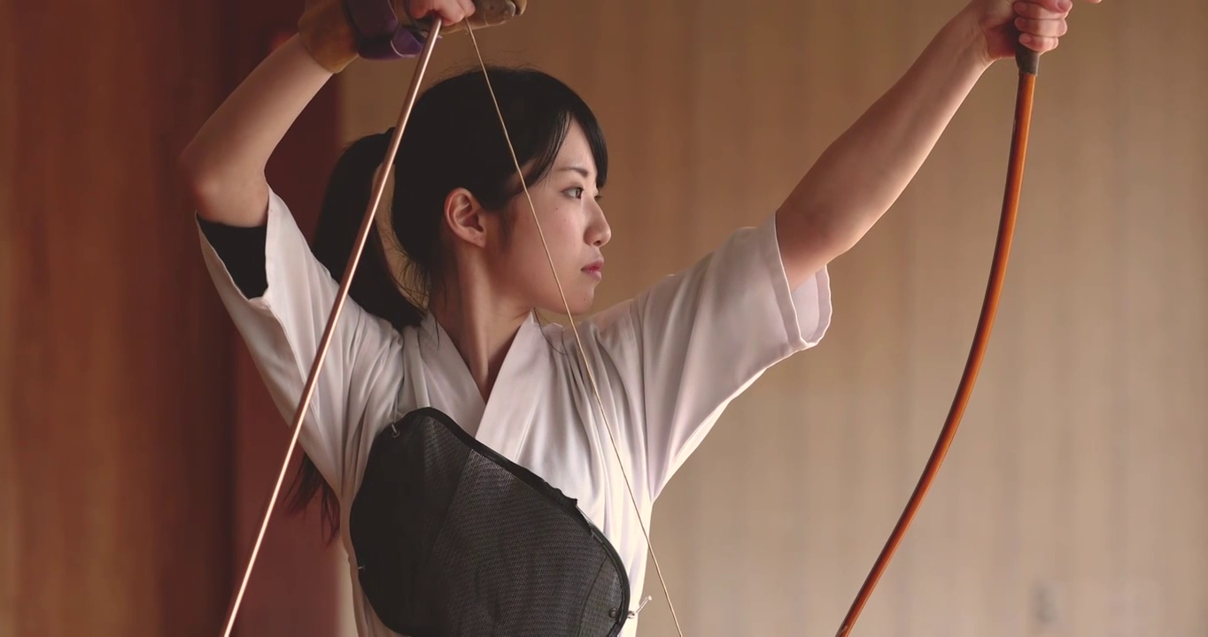 年轻的日本女子练习传统的共同语射箭视频下载