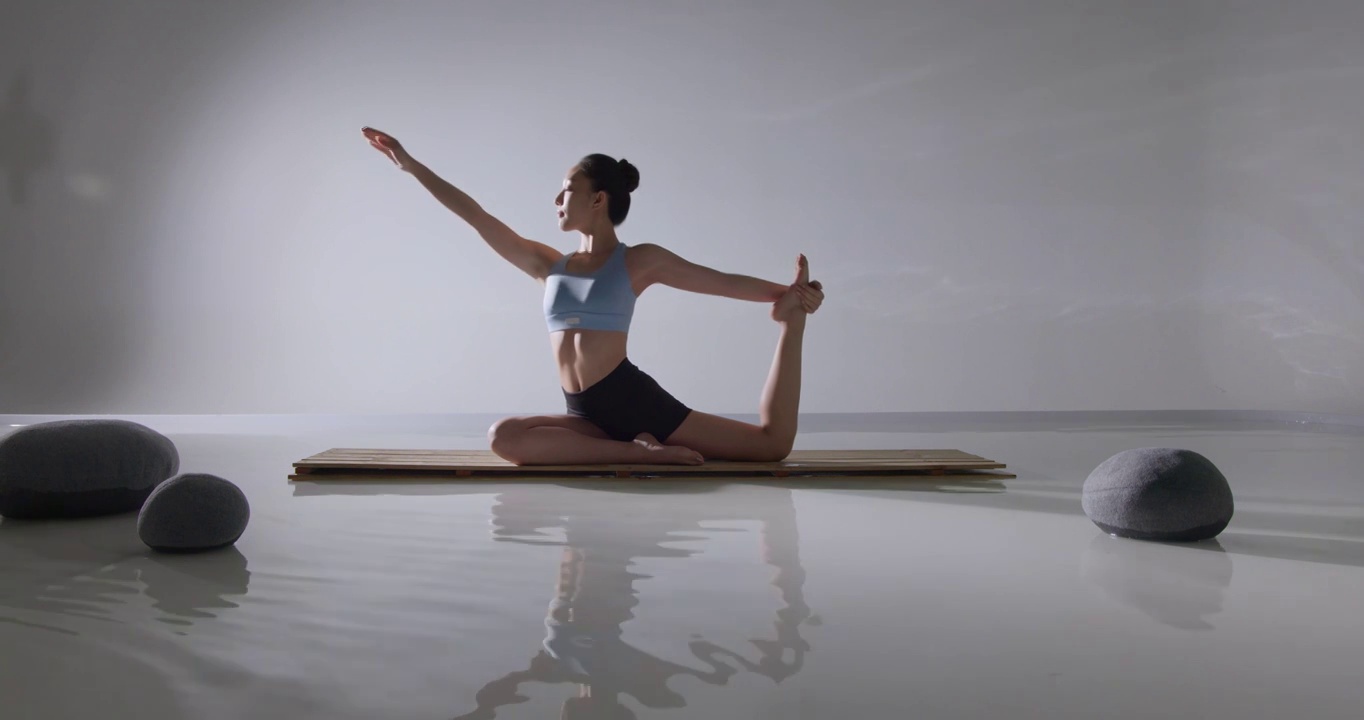 年轻女人在水面上练习瑜伽视频下载