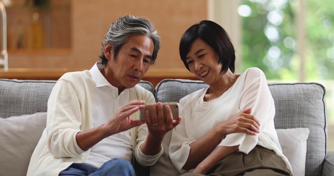 日本老年夫妇在沙发上视频通话视频素材