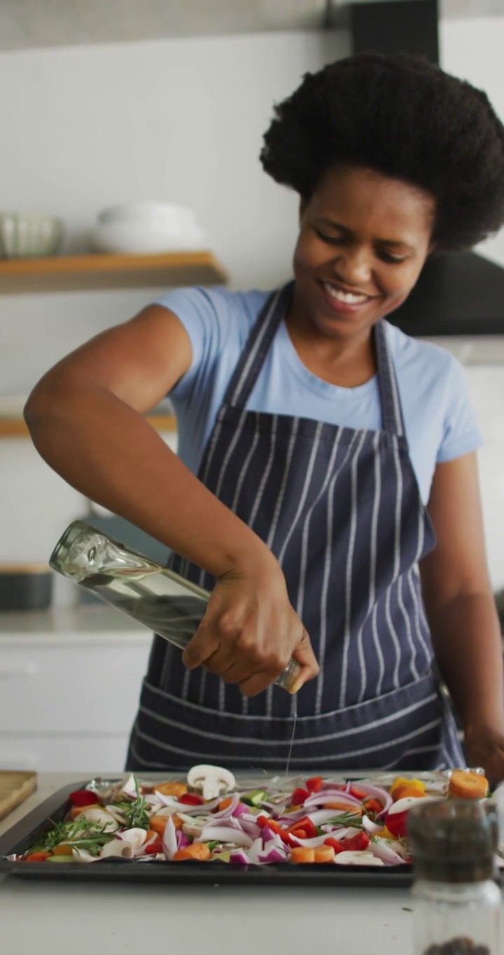 一个快乐的非裔美国女人在家做饭的垂直视频视频下载