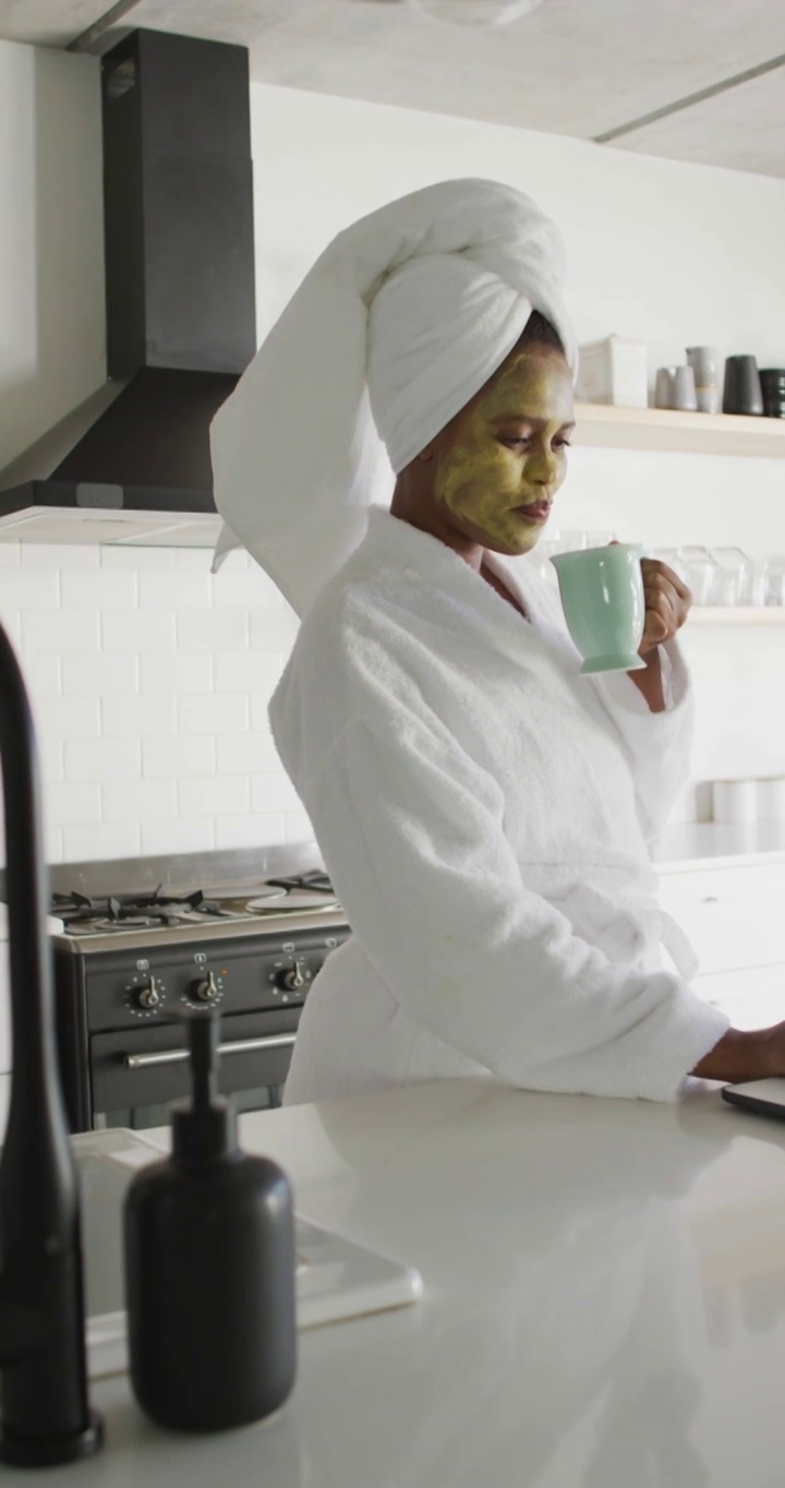垂直视频快乐的非洲裔美国妇女与面具在家里喝咖啡视频下载