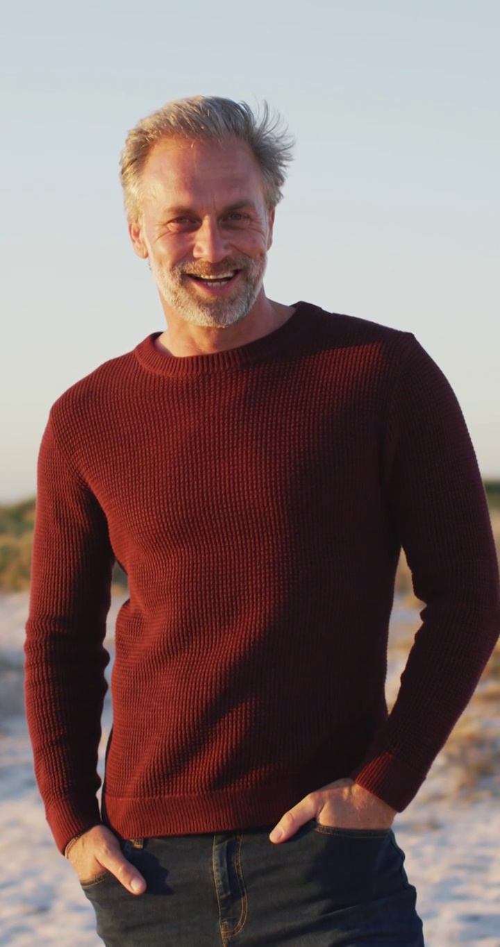 垂直视频肖像微笑白人男子在海滩，享受休闲时间视频下载