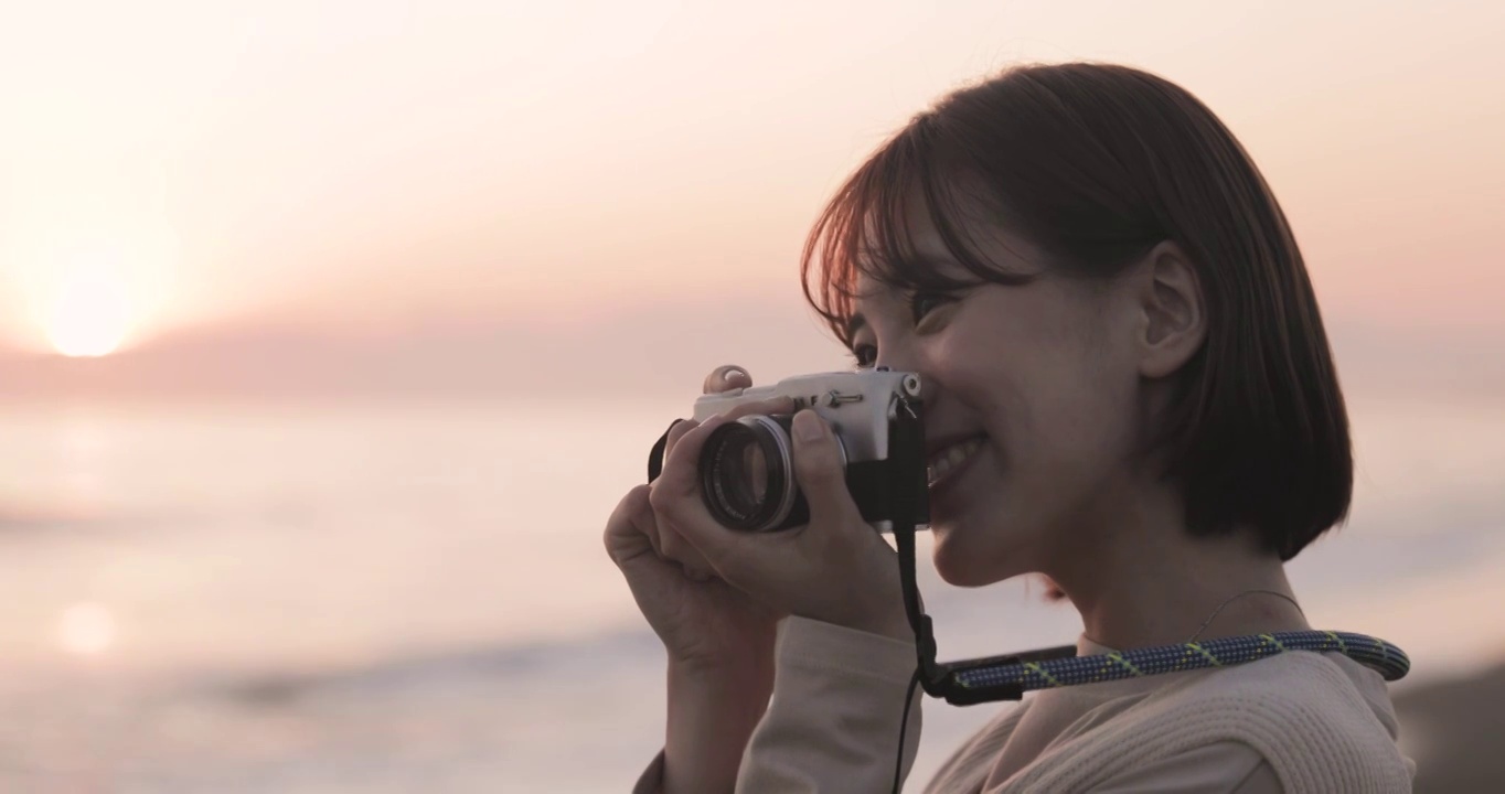 年轻的日本女子在海滩上欣赏日落视频下载