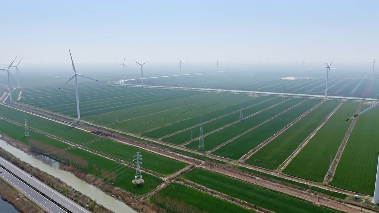 航拍高视角田地间的风力发电涡轮机视频素材