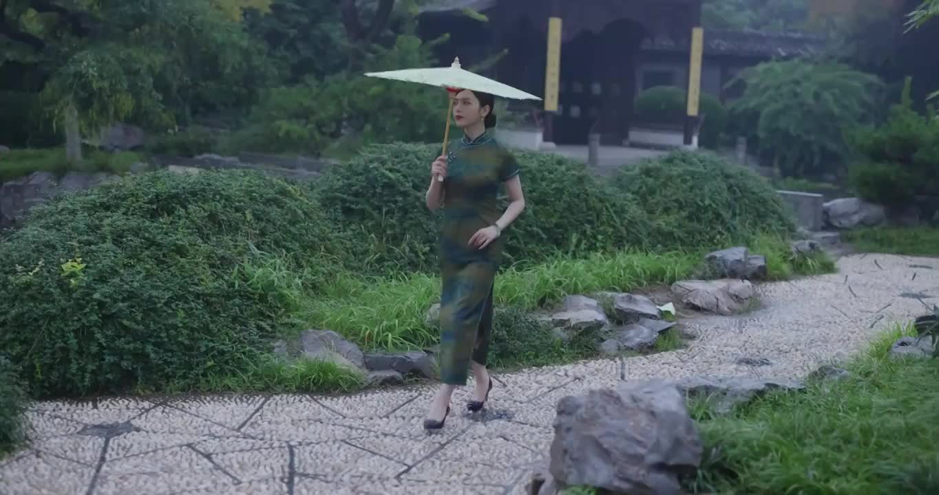 旗袍美女在江南园林的雨中行走全身像视频素材