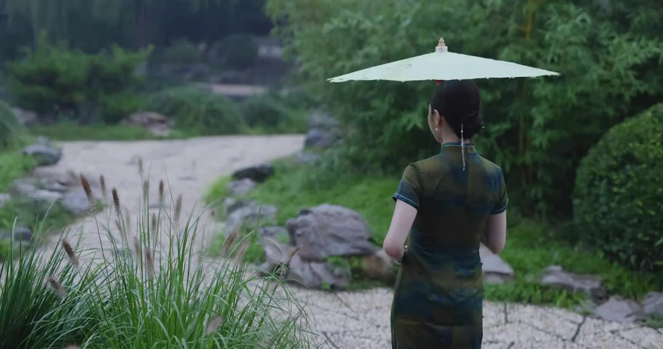 旗袍美女在江南园林的雨中行走背影视频素材