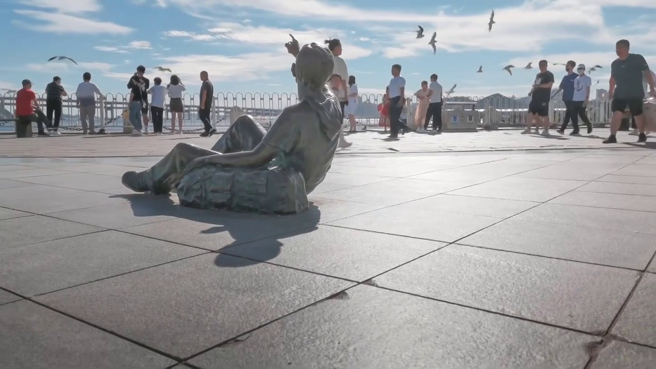中国大连星海广场男生雕塑指向海鸥和天空慢镜视频下载
