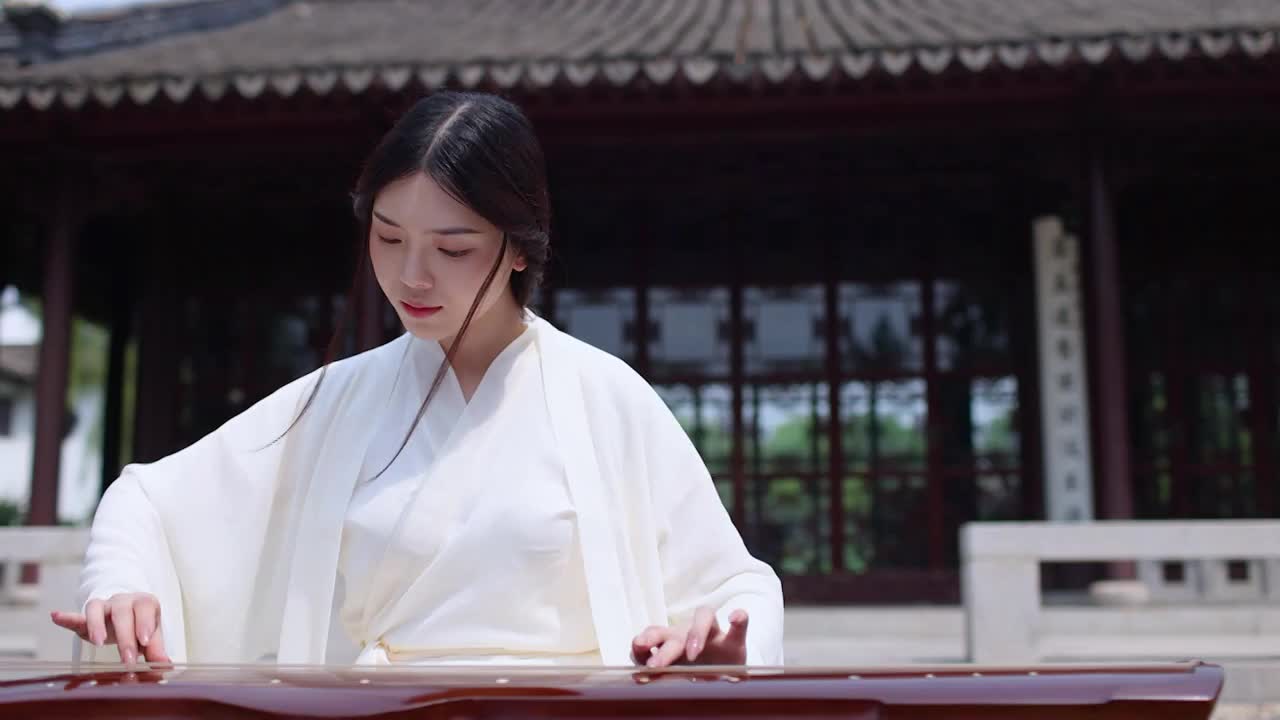 一个汉服美女坐在中式大殿前弹古琴特写（选编）视频素材
