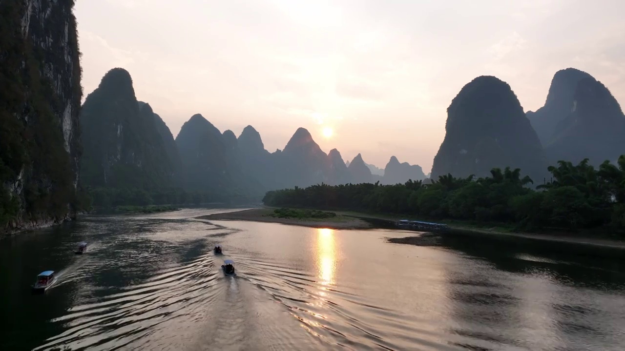 日落时分阳朔漓江两岸的山和水面上的竹筏视频下载