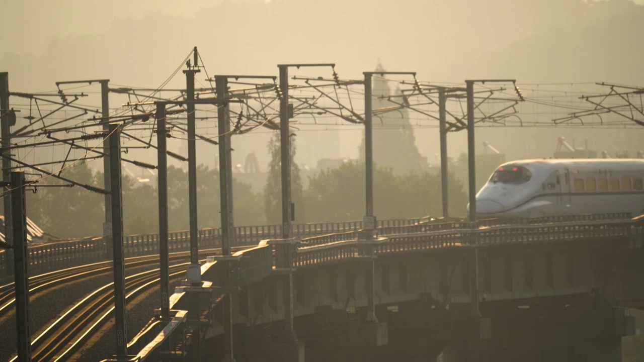 日出阳光下在城市中穿行的高铁火车视频下载