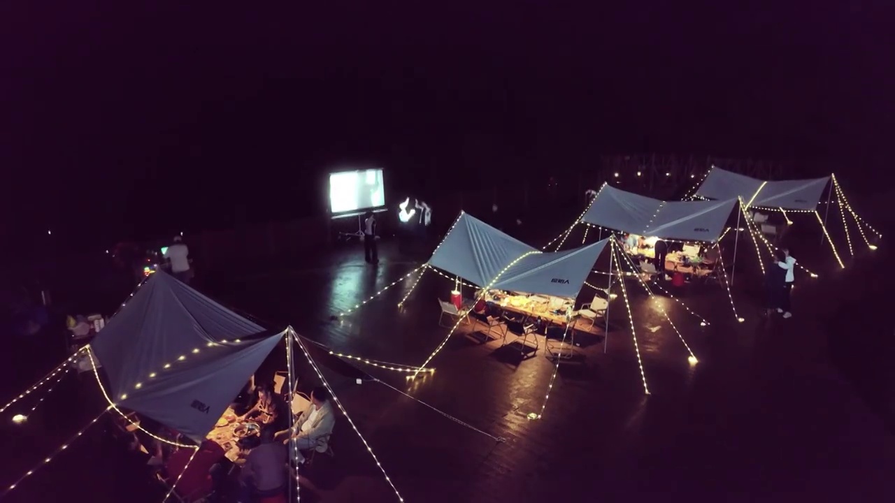 户外露营基地夜晚航拍团建野外帐篷人群聚会视频素材